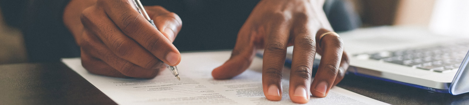 Close up of hands signing document