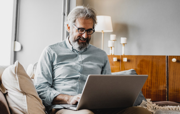 Mature man on the computer in living space